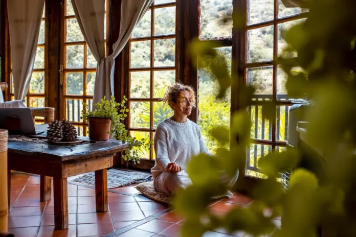 femme faisant du yoga dans son jardin d'hiver